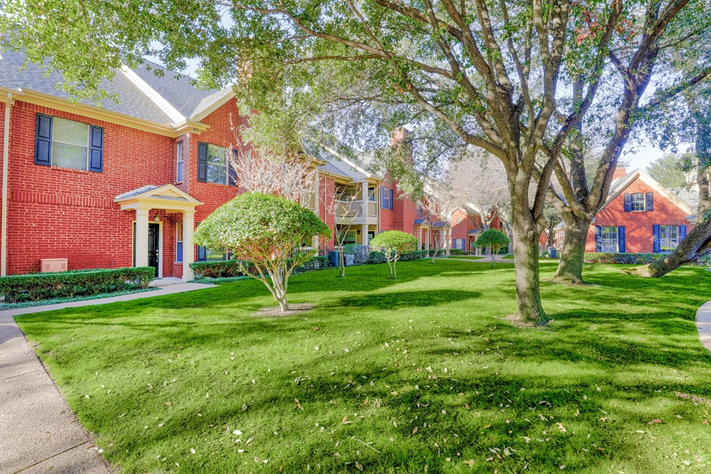 Exterior of apartment with grassy lawn and trees at SaddleBrook Apartments, Texas, 75248