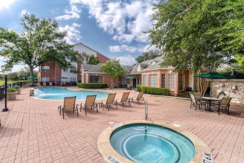 A pool surrounded by chairs and trees.