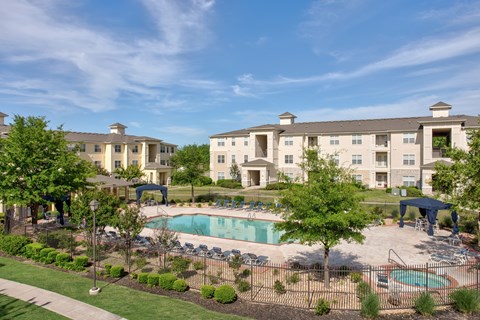 A large building with a pool in front of it.