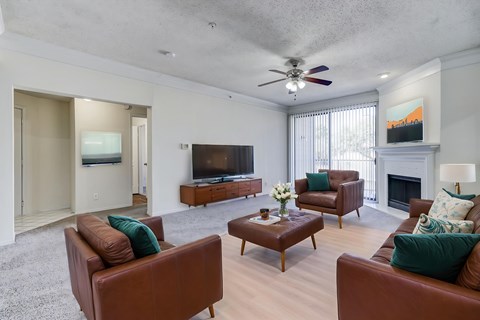 A living room with brown leather couches and a fireplace.