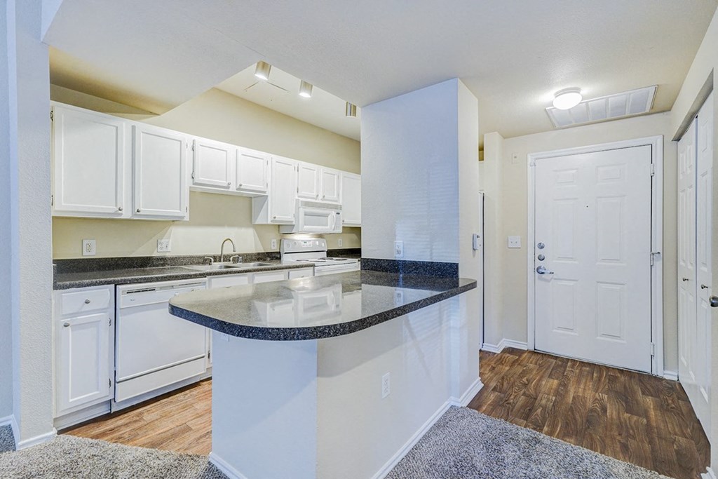 Interior kitchen with white cabinets and a counter top at Villas at Katy Trail Apartments, Dallas