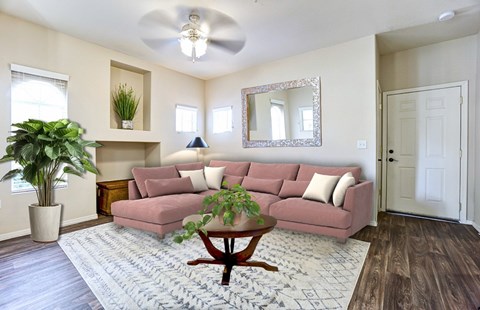 A living room with a pink couch and a ceiling fan.