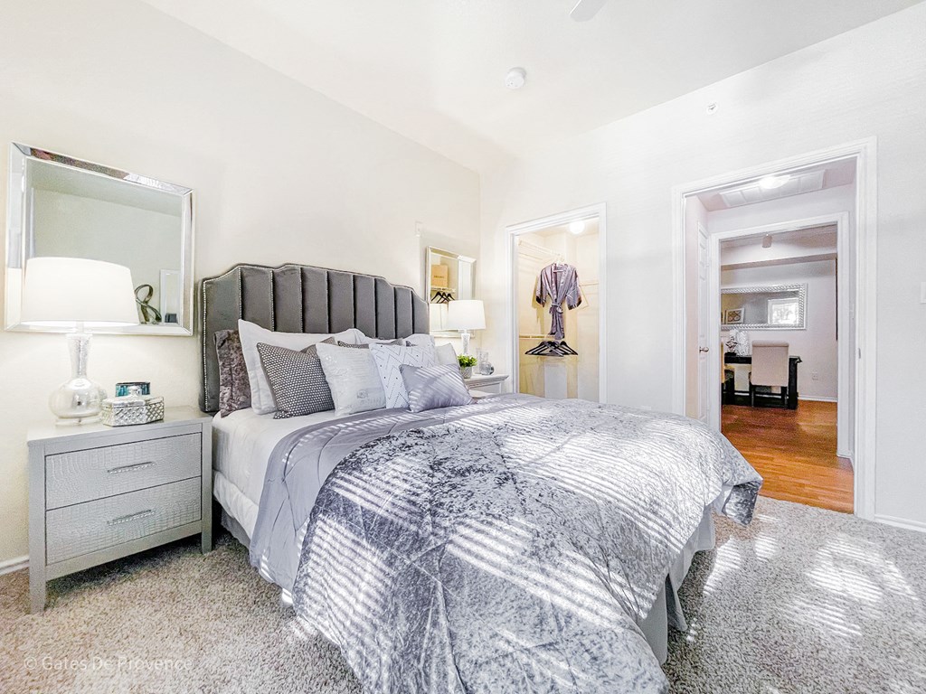 Interior bedroom with grey features and white walls at Gates de Provence Apartments, Dallas, TX