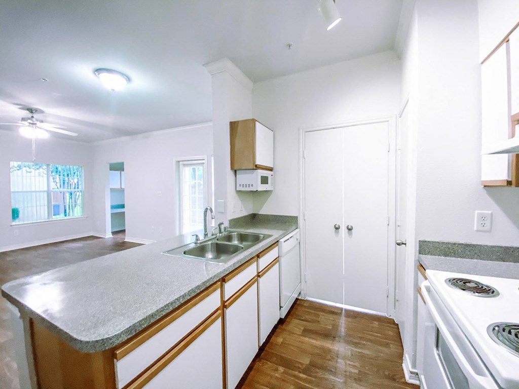 White kitchen appliances with hardwood flooringat Tuscany Square, Dallas, TX