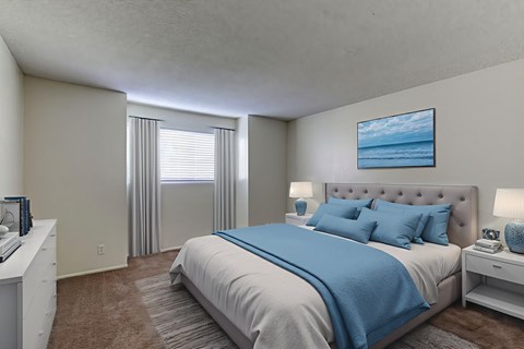 A bedroom with a large bed and a painting of a beach scene on the wall.