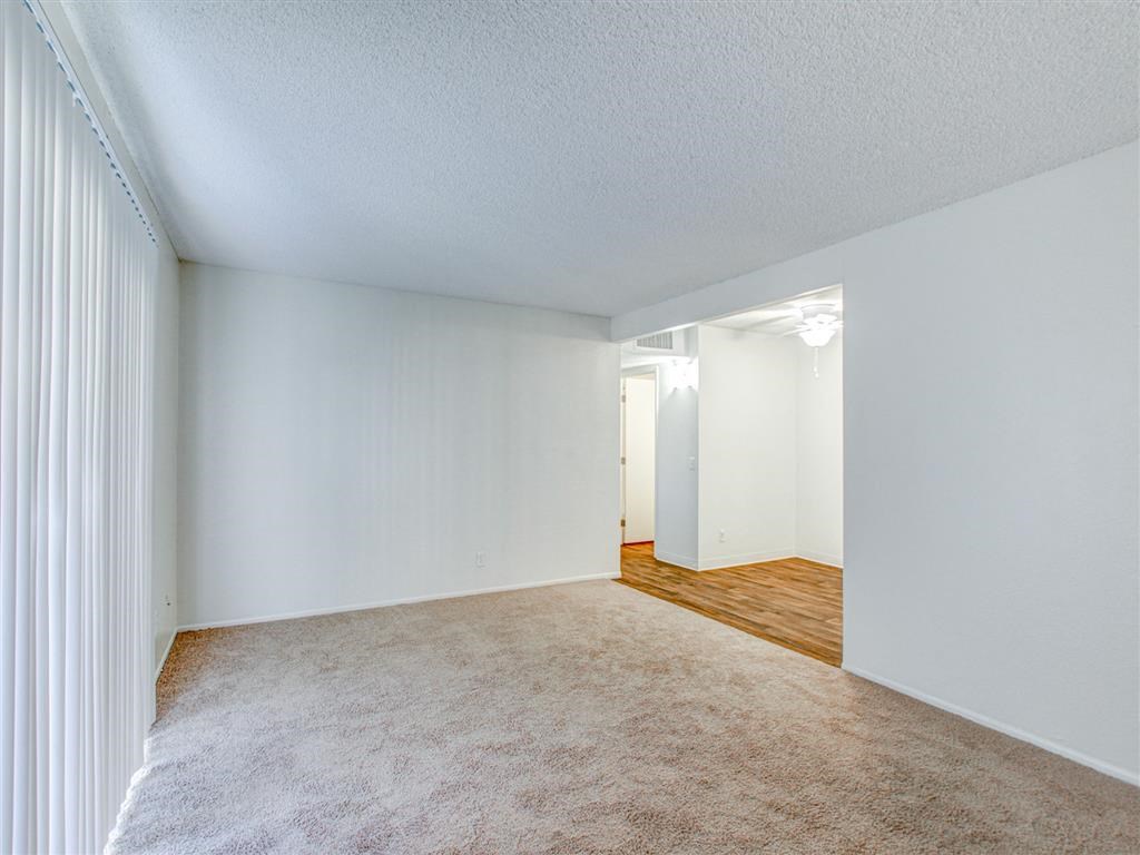 Interior living room with beige carpeting at Woodlake, Escondido, California