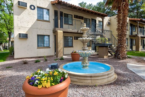 A house with a fountain in front of it.