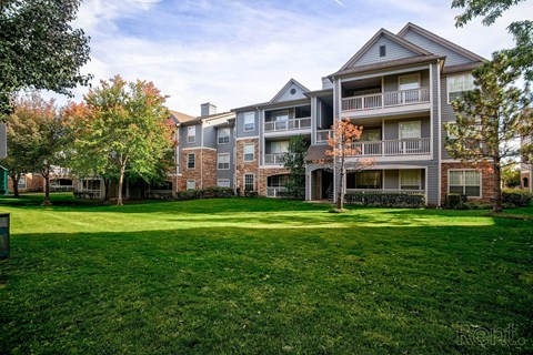 A large grassy area in front of apartment buildings.
