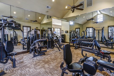 A spacious gym with a variety of equipment including treadmills, weights, and exercise machines.