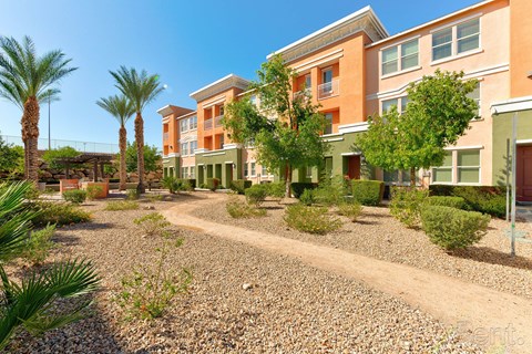 A sunny day at a residential area with apartment buildings and palm trees.