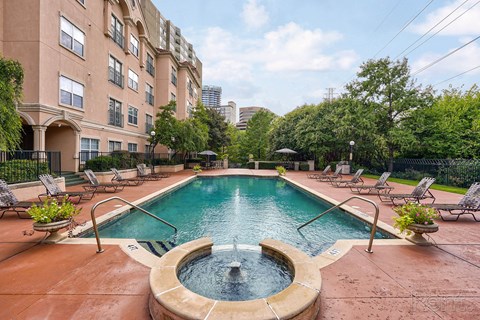A large outdoor pool with a fountain in the middle of it.