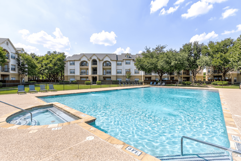 A large swimming pool in front of apartment buildings.