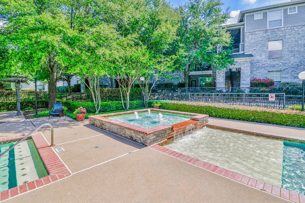 a fenced in swimming pool with trees and a building in the background