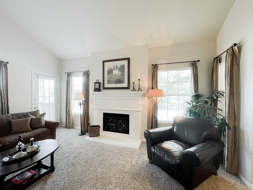 Living room with couch and table, ceiling fan and light at SaddleBrook Apartments, Dallas, TX, 75248