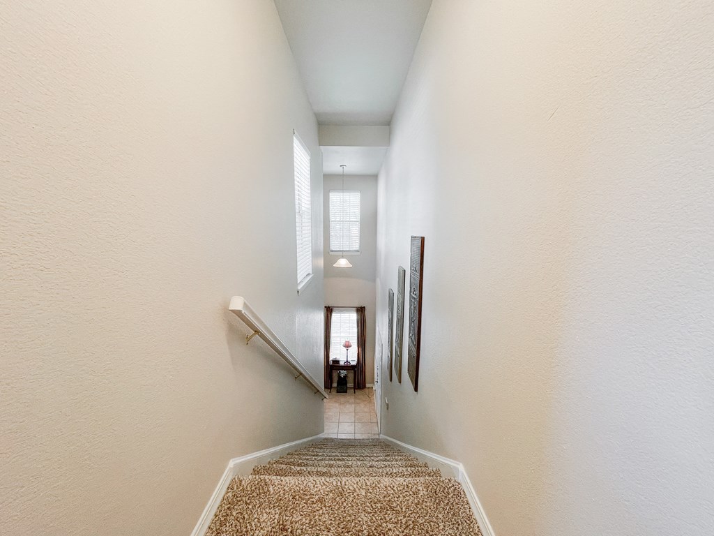 Staircase with beige carpeting at SaddleBrook Apartments, Dallas, 75248