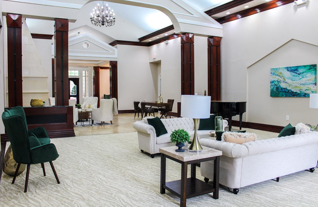 Interior of leasing office with white archway, chandelier, and white sofas at Montfort Place Apartments, Dallas, Texas