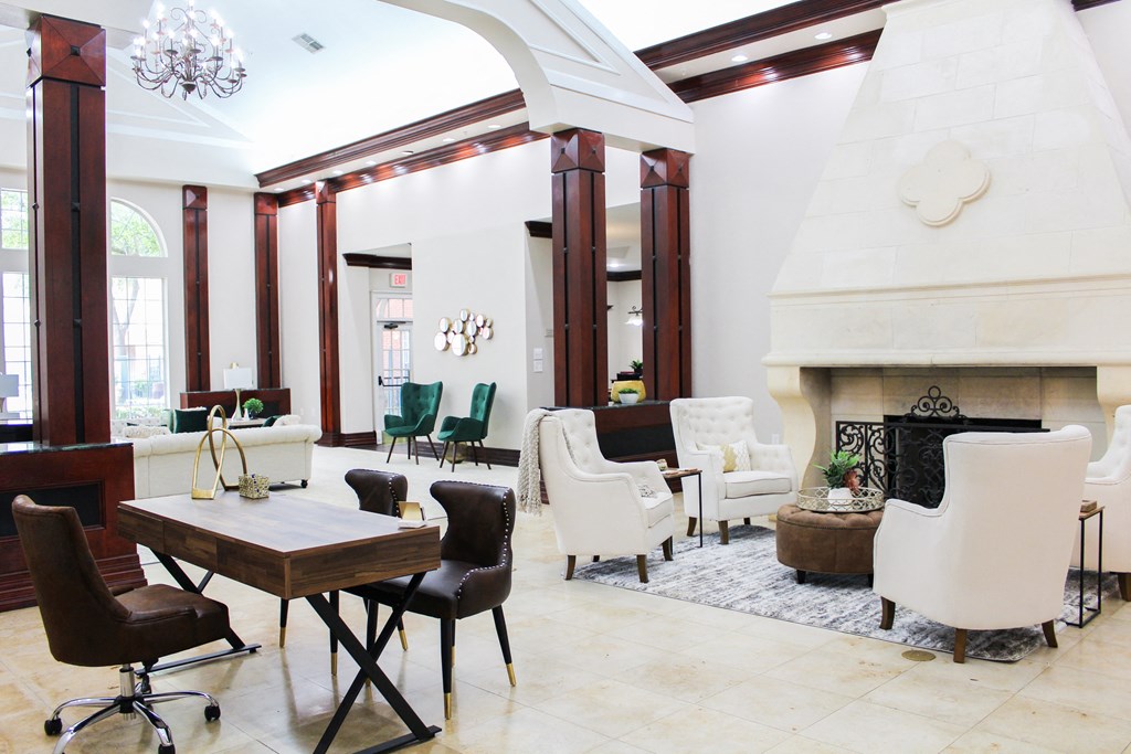 Interior of leasing office with crown molding, white walls, fireplace, lounge are and desk set up at Montfort Place Apartments, Texas, 75254