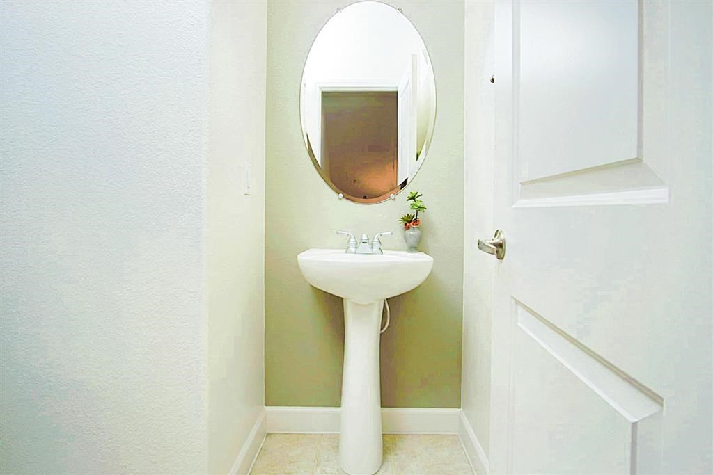 Bathroom sink with a round mirror at Croix Townhomes, Henderson, NV, Nevada