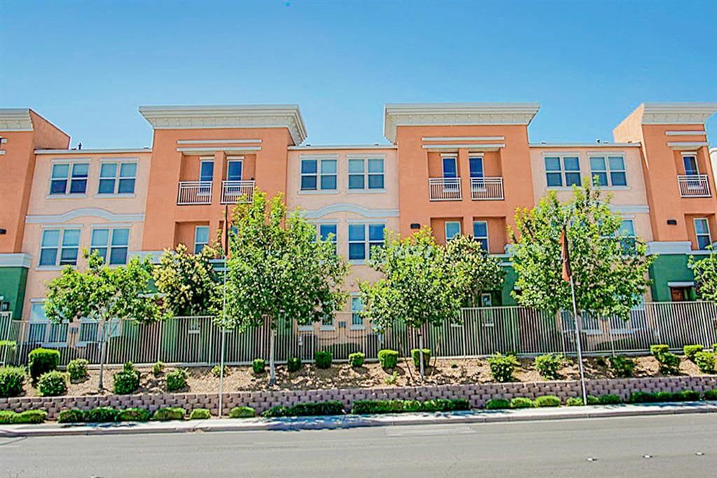 Apartment building with a fence and a garden at Croix Townhomes, Henderson, NV, Nevada