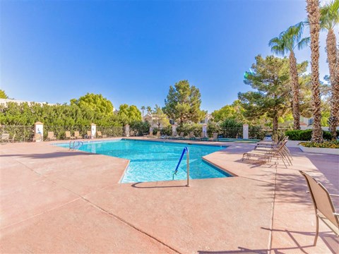 Heated pool deck with palm trees surrounding at Country Club at Valley View - 55+ Senior Community Apartments, Las Vegas, NV