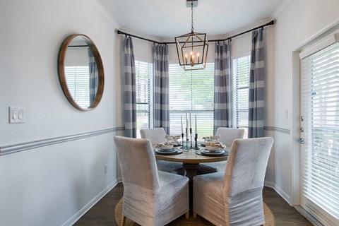 A dining room with a table set for four.