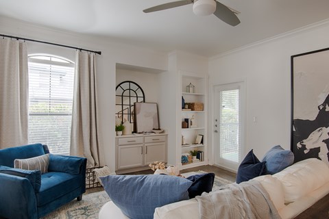 A living room with a blue couch and a white couch.