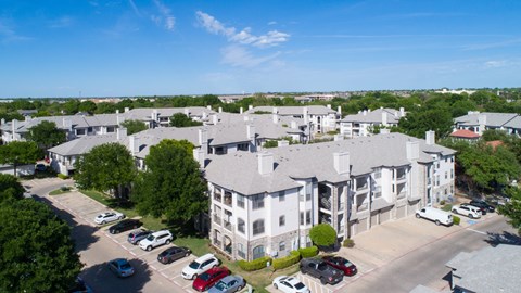 A large white building with a parking lot in front of it.