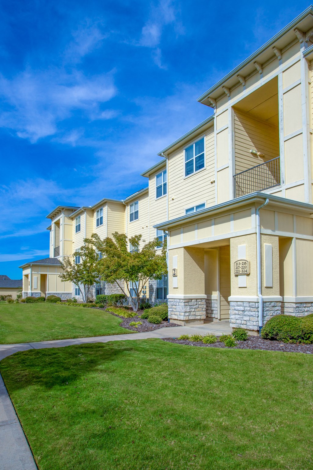 Exterior of apartment with green lawn and a small tree at Sonoma Grande Apartments, Tulsa