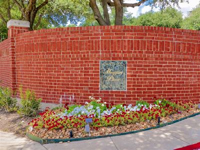 Lush front landscaping and brick façade of Montfort Place in North Dallas, TX, For Rent. Now leasing 1 and 2 bedroom apartments.