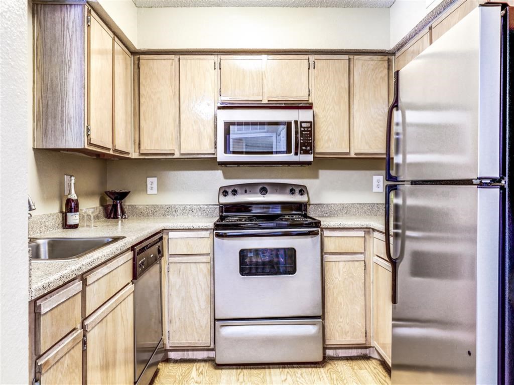 Stainless Steel microwave, dishwasher and refrigerator at Trinity Square Apartments For Rent in North Dallas, TX.