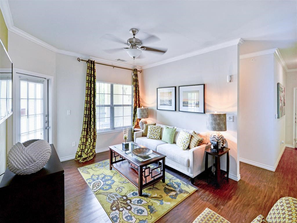 Living room area with large windows and a white couch at Mission at La Villita Apartments, Irving 75039