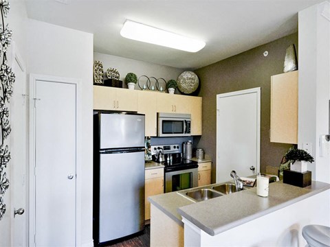 a kitchen with a stainless steel refrigerator and a sink