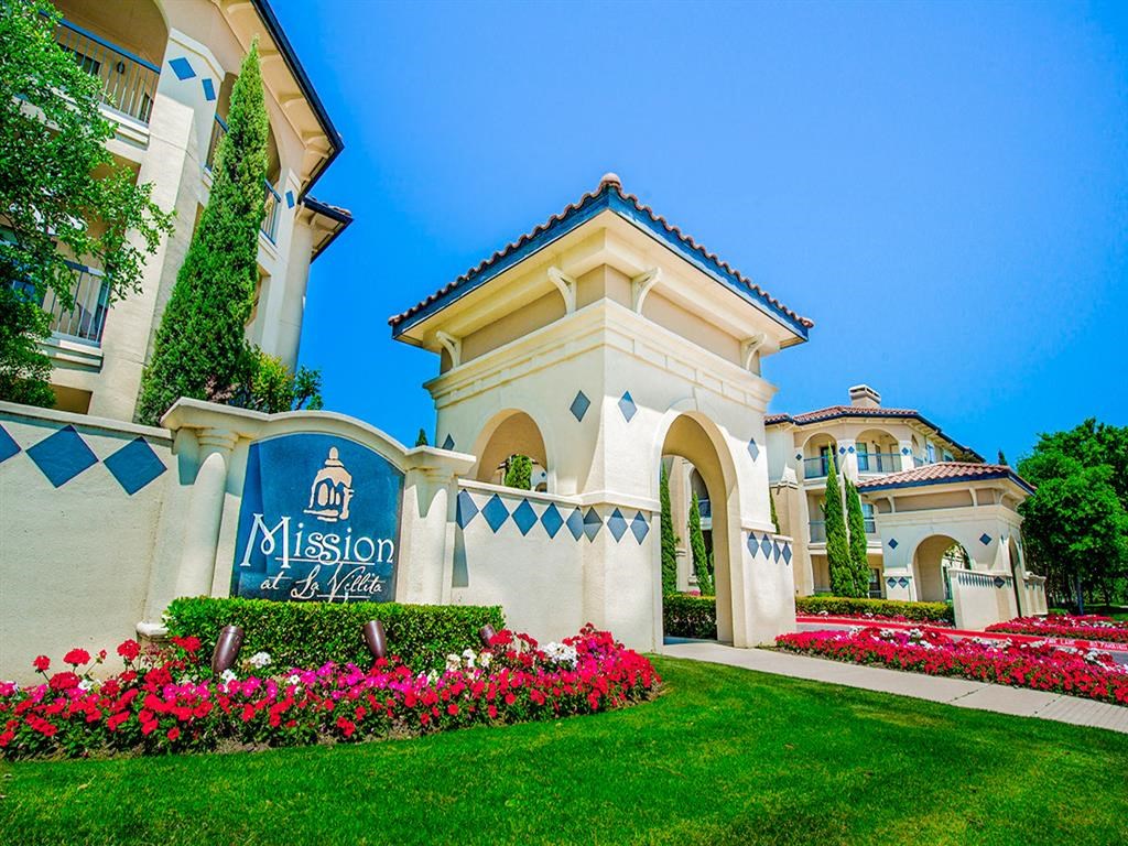 Community entrance with florals and luscious grass at Mission at La Villita Apartments, Irving