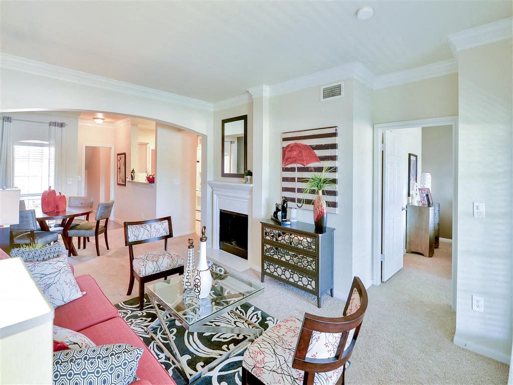 Living room view with fireplace, dining room and pass through bar at Bentley Place at Willow Bend Apartments in West Plano, TX, For Rent. Now leasing 1, 2, and 3 bedroom apartments.