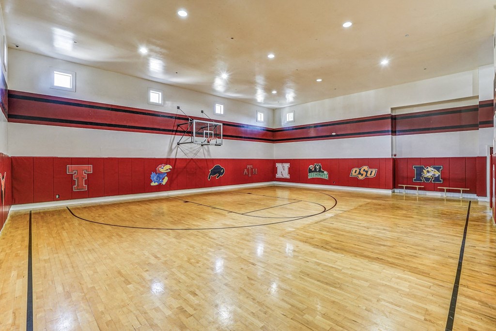 the gym is equipped with a basketball court and hardwood floors