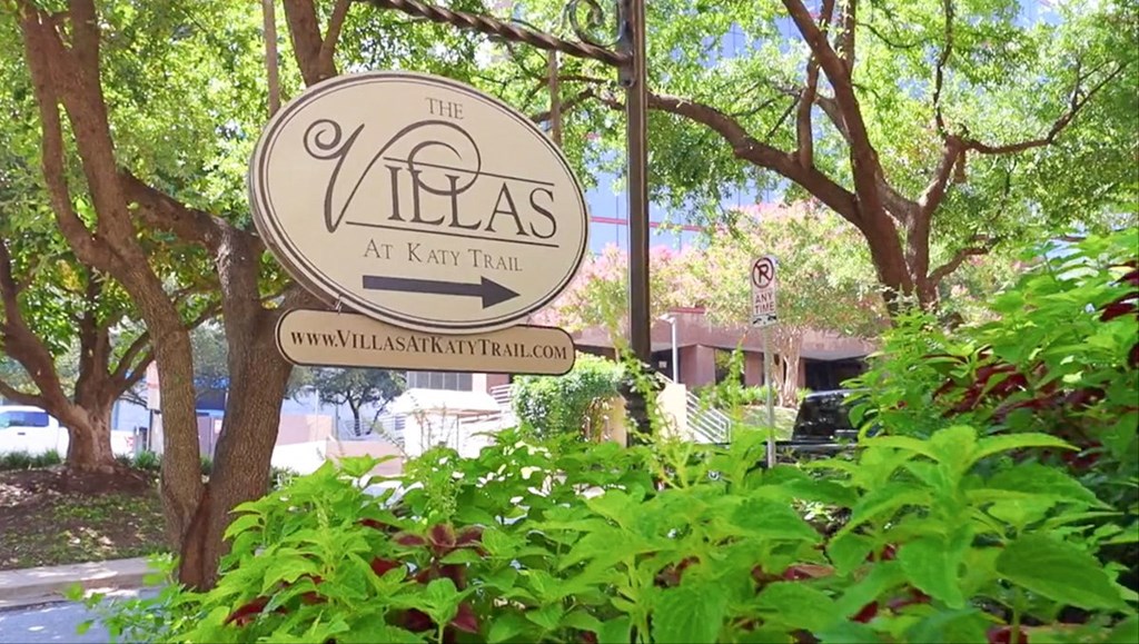 Property signage with green bushes at Villas at Katy Trail Apartments, Dallas, 75201