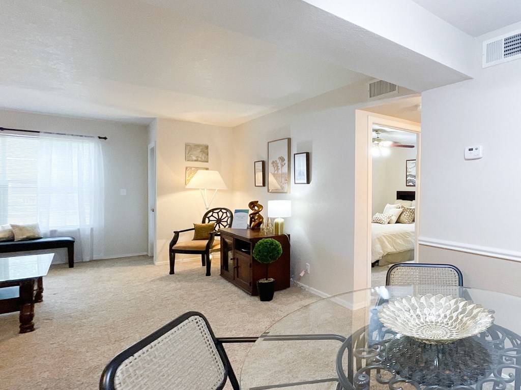 Spacious living room with glass dining table at Greenbriar Apartments, Tulsa, OK