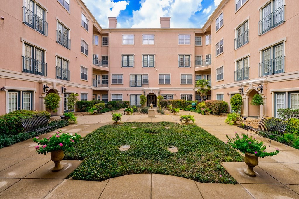 Exterior courtyard with a fountain in the middle of an apartment building at Villas at Katy Trail Apartments, Dallas