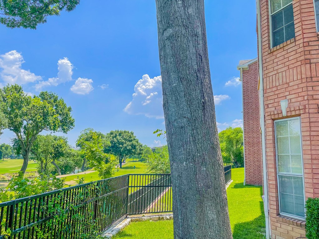 Exterior of apartment with green lawn at Turnberry Isle Apartment Homes, Dallas, Texas