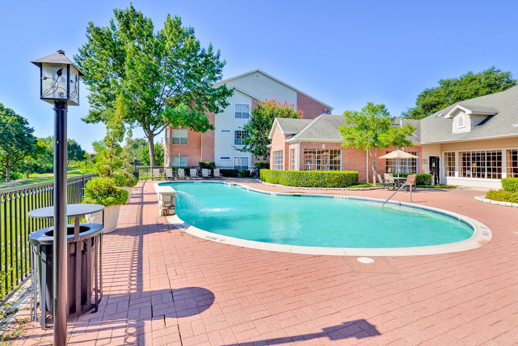 Outdoor swimming pool view with clubhouse nearby at Turnberry Isle Apartment Homes, Dallas