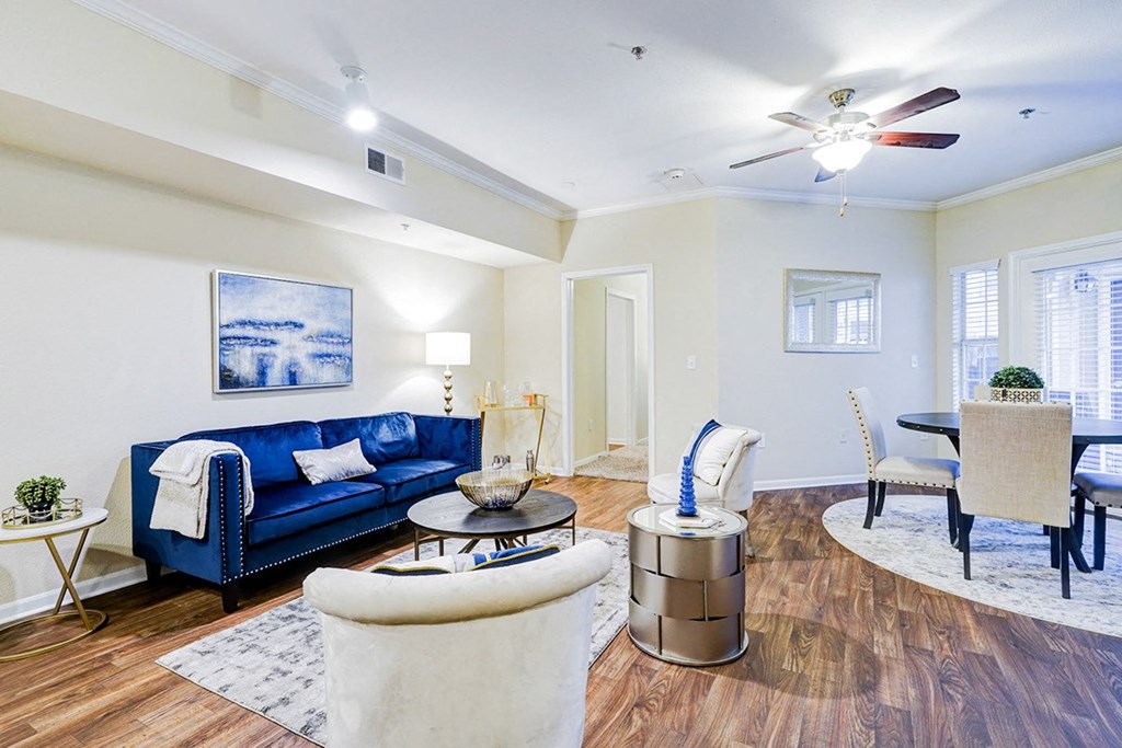 Interior living room with a blue couch and a ceiling fan at Villas at Katy Trail Apartments, Dallas, 75201