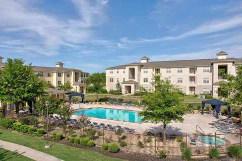 A large building with a pool in front of it.