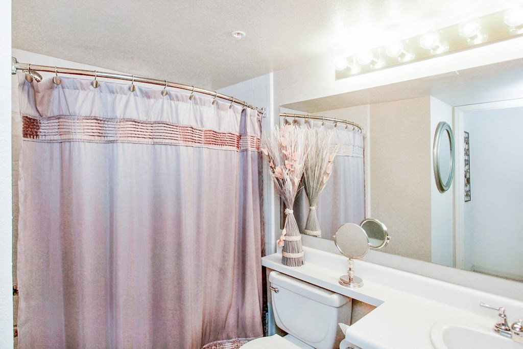 Bathroom interior with light pink shower curtain at Riverside Park Apartments, Tulsa 74136