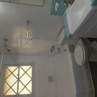 A bathroom with a shower and a window.