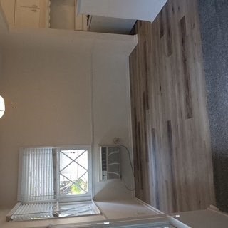 A white bathroom with a window and a shower.