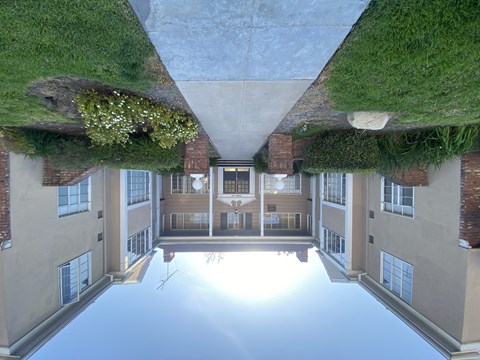 A building with a green roof and a courtyard in the middle.