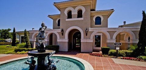 A large house with a fountain in front of it.