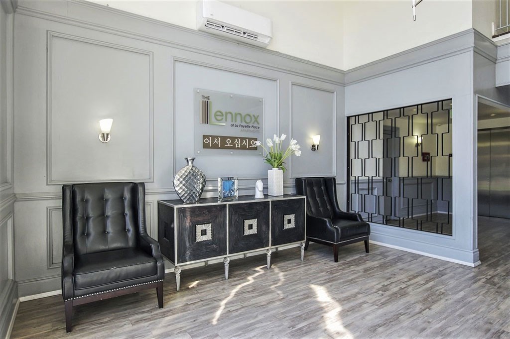 a lobby with black leather chairs and a table with a mirror