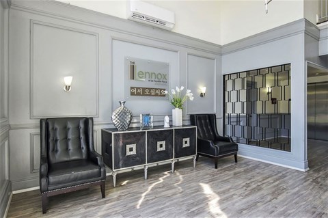 a lobby with black leather chairs and a table with a mirror