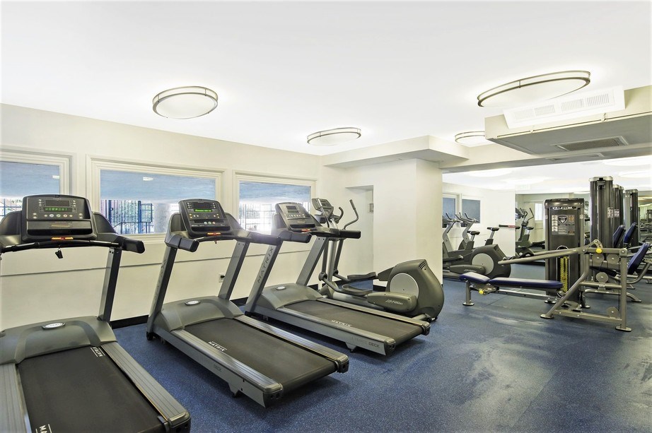 a gym with cardio equipment and windows in a building